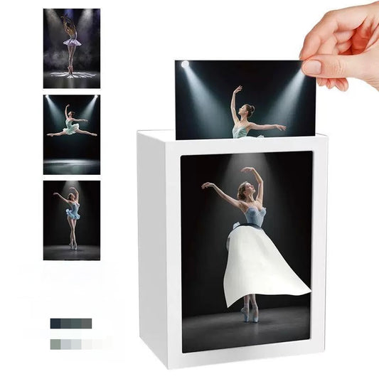 Ballet dancer in a white dress on a white box with a hand lifting one of the images.