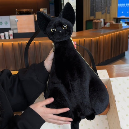 Black cat-shaped bag held by a person in an indoor setting