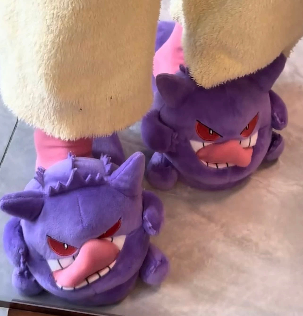 Pair of purple Gengar slippers on a light surface