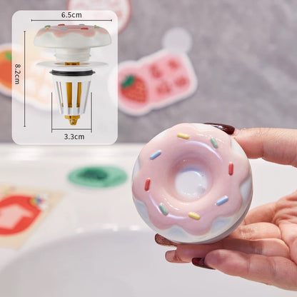 Pink donut-shaped light bulb held by a hand with dimensions displayed.
