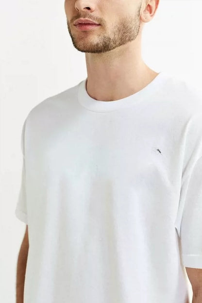Man wearing a plain white t-shirt with a small logo on a white background