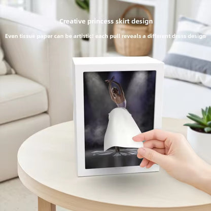 Framed artwork on a table with a hand holding it, showcasing a princess skirt design.