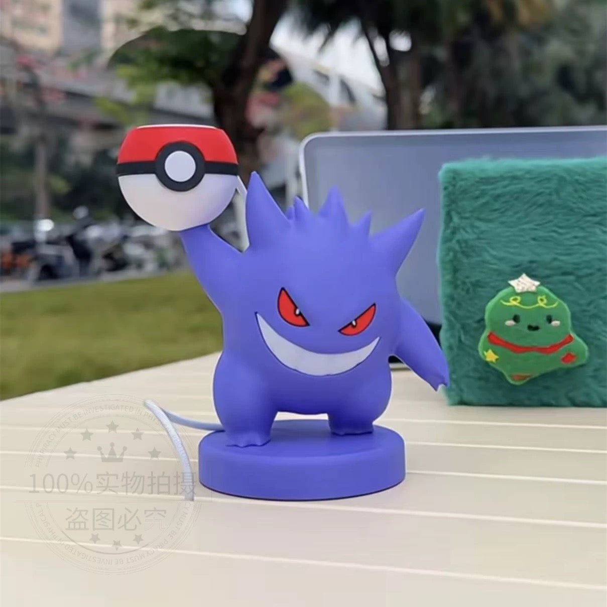 Blue cartoon character with a red and white object on a table outdoors