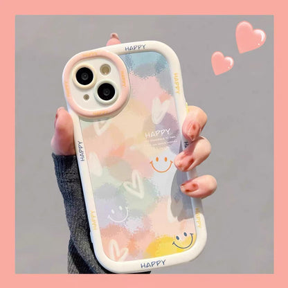 Phone case with smiley face design held by a hand on a gray background