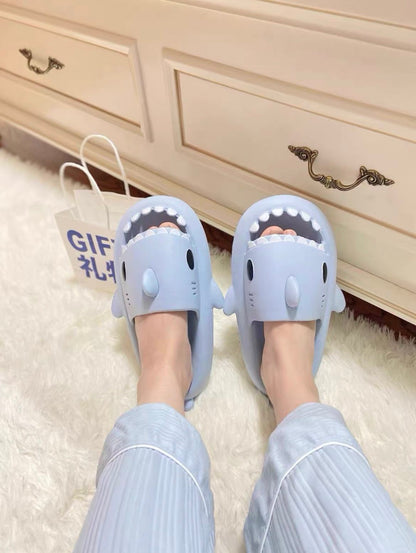 Shark-themed slippers worn indoors on a carpeted floor.