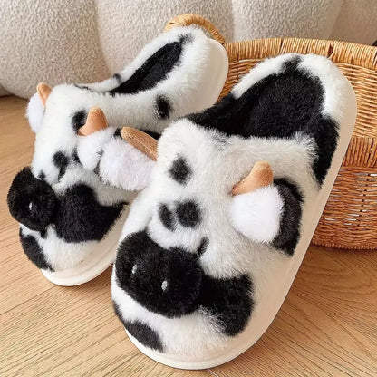Pair of cow-patterned slippers on a wooden floor with a wicker basket in the background.